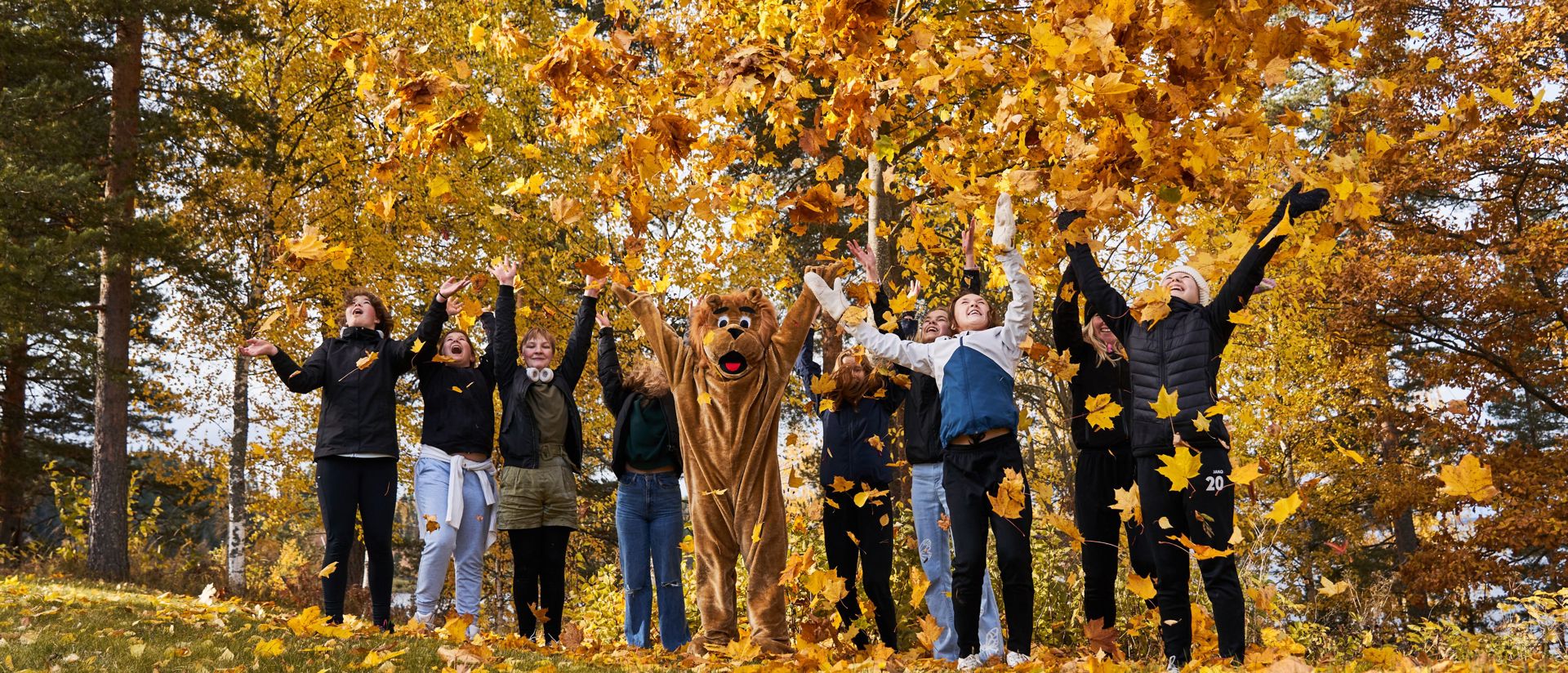 Ihmisiä vaahteranlehtisateessa