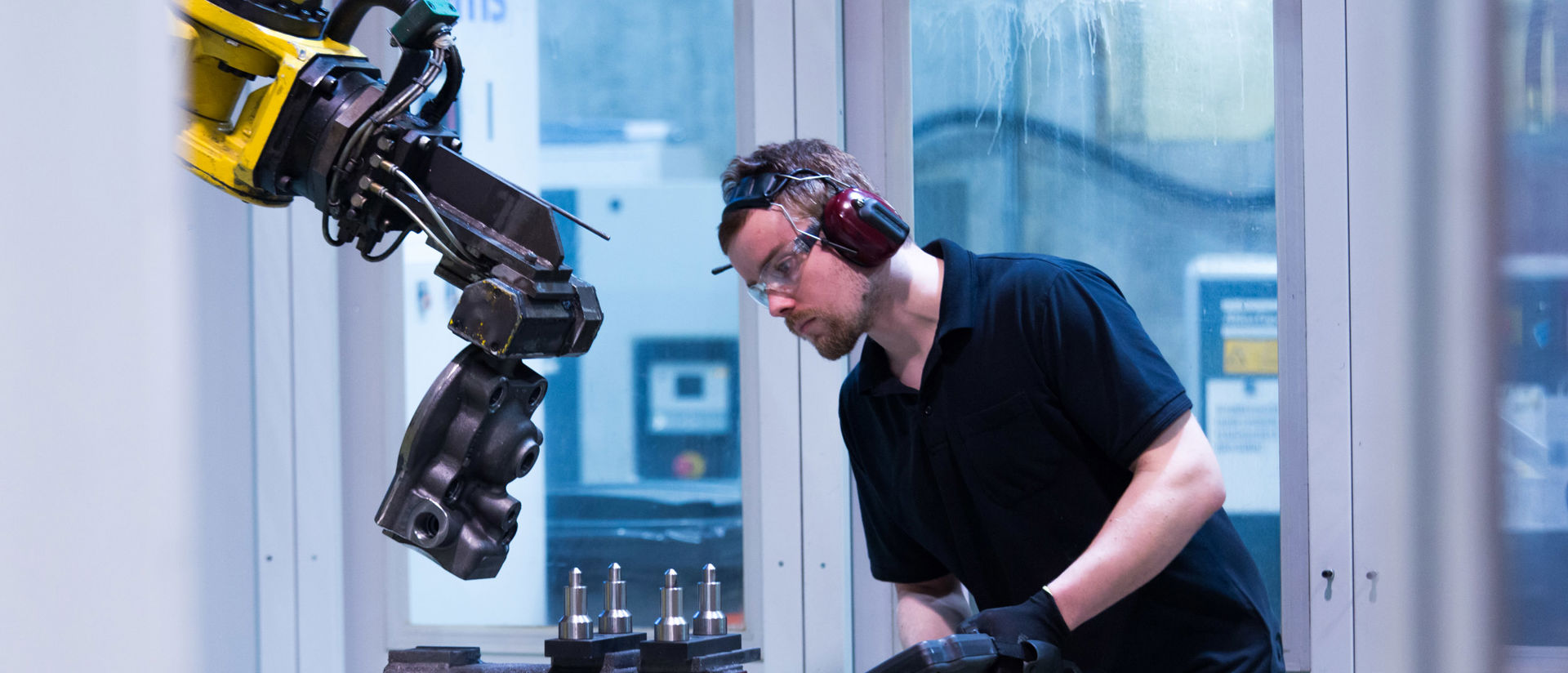 Metallityöntekijä ja teollisuusrobotti