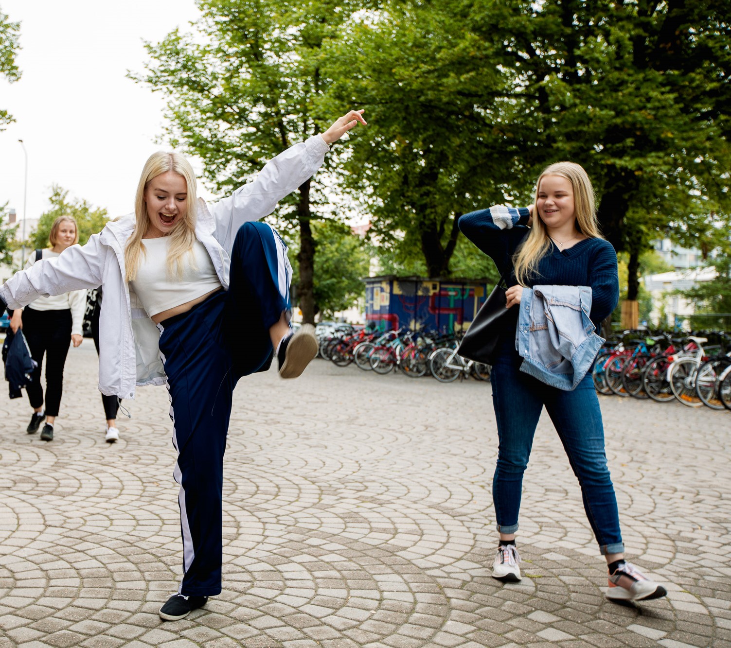 kaksi nuorta tyttöä kävelee kadulla iloisina