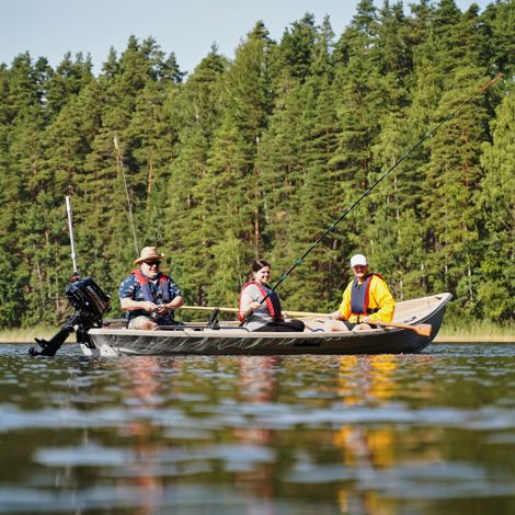 Kolme kalastajaa veneessä Saimaalla, metsä taustalla, järvi edessä