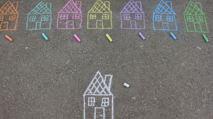 Asvaltille piirrettyjä erivärisiä taloja sekä väriliidut