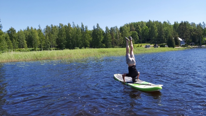 Seisoo päällään sup-laudalla